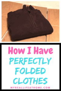 Neatly folded brown sweater on top of a handmade cardboard clothes folder
