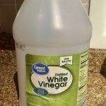 Large jug of white vinegar sitting on granite kitchen counter