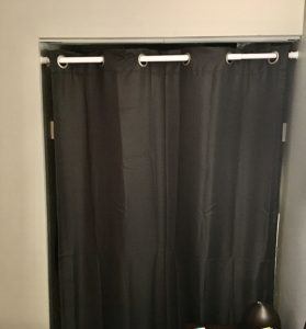 Gray curtain covering small closet