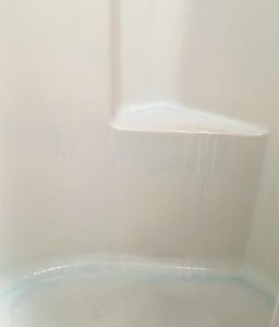 Shower surround with blue detergent sprayed on it